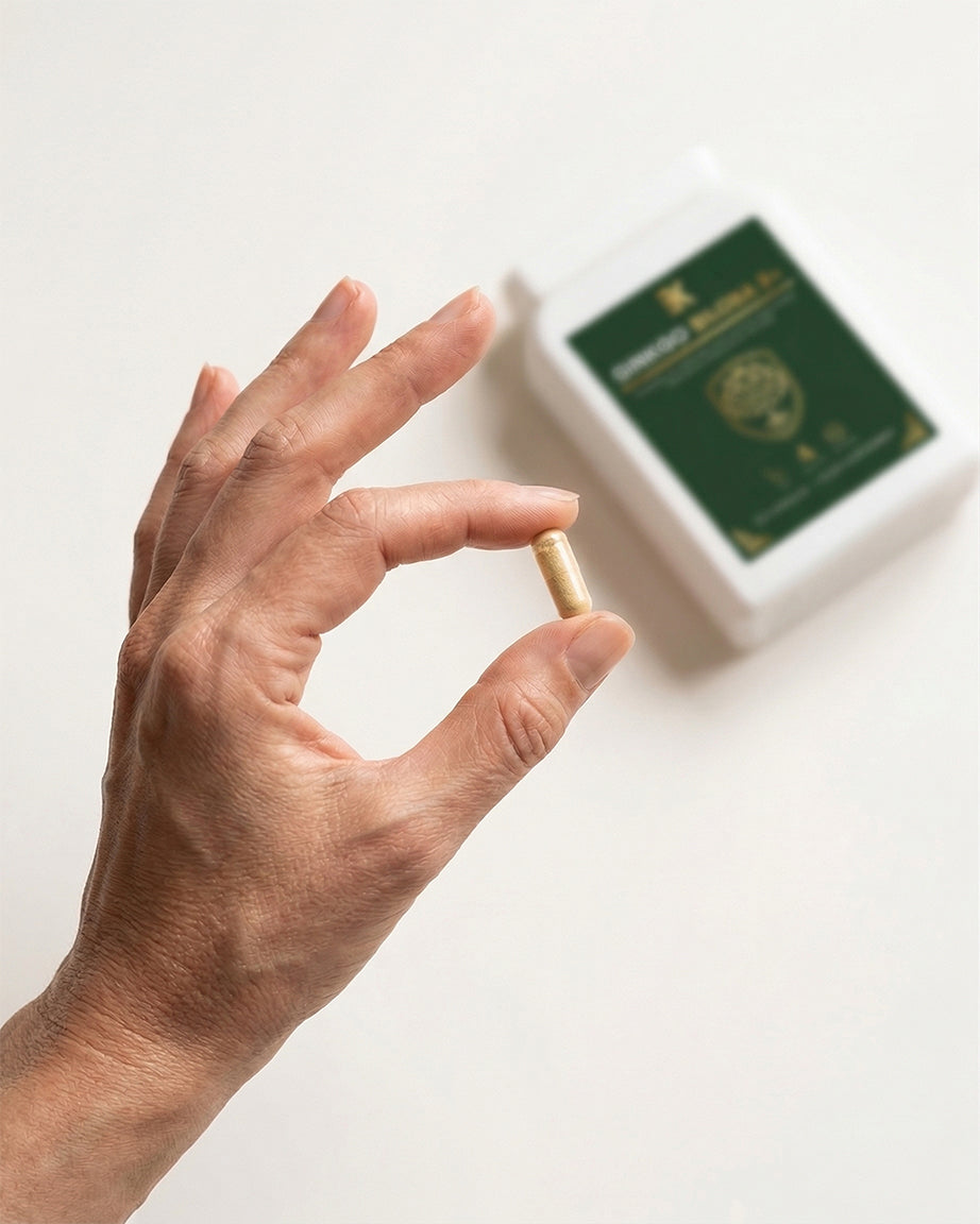Hand holding a small object with a blurred green box in the background
